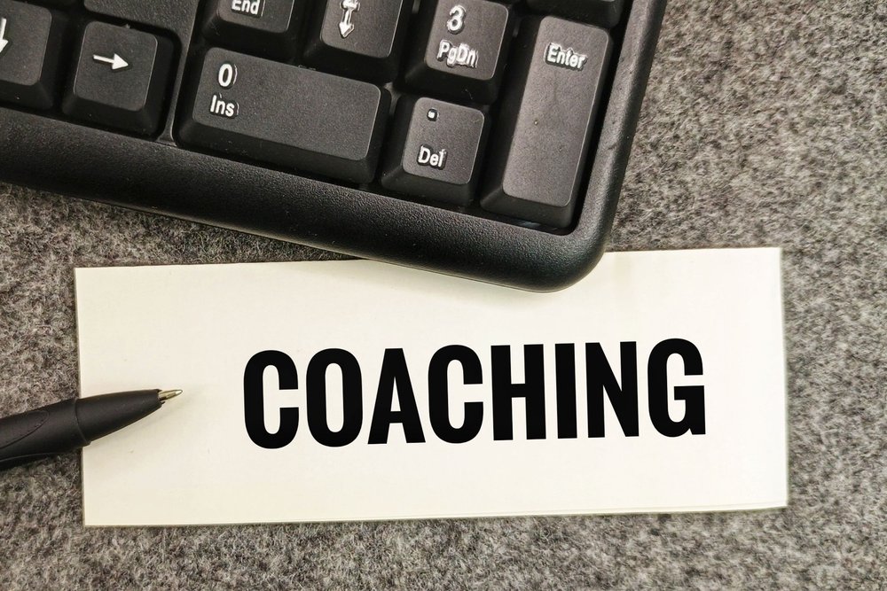 Carte portant le mot coaching posée près d'un clavier